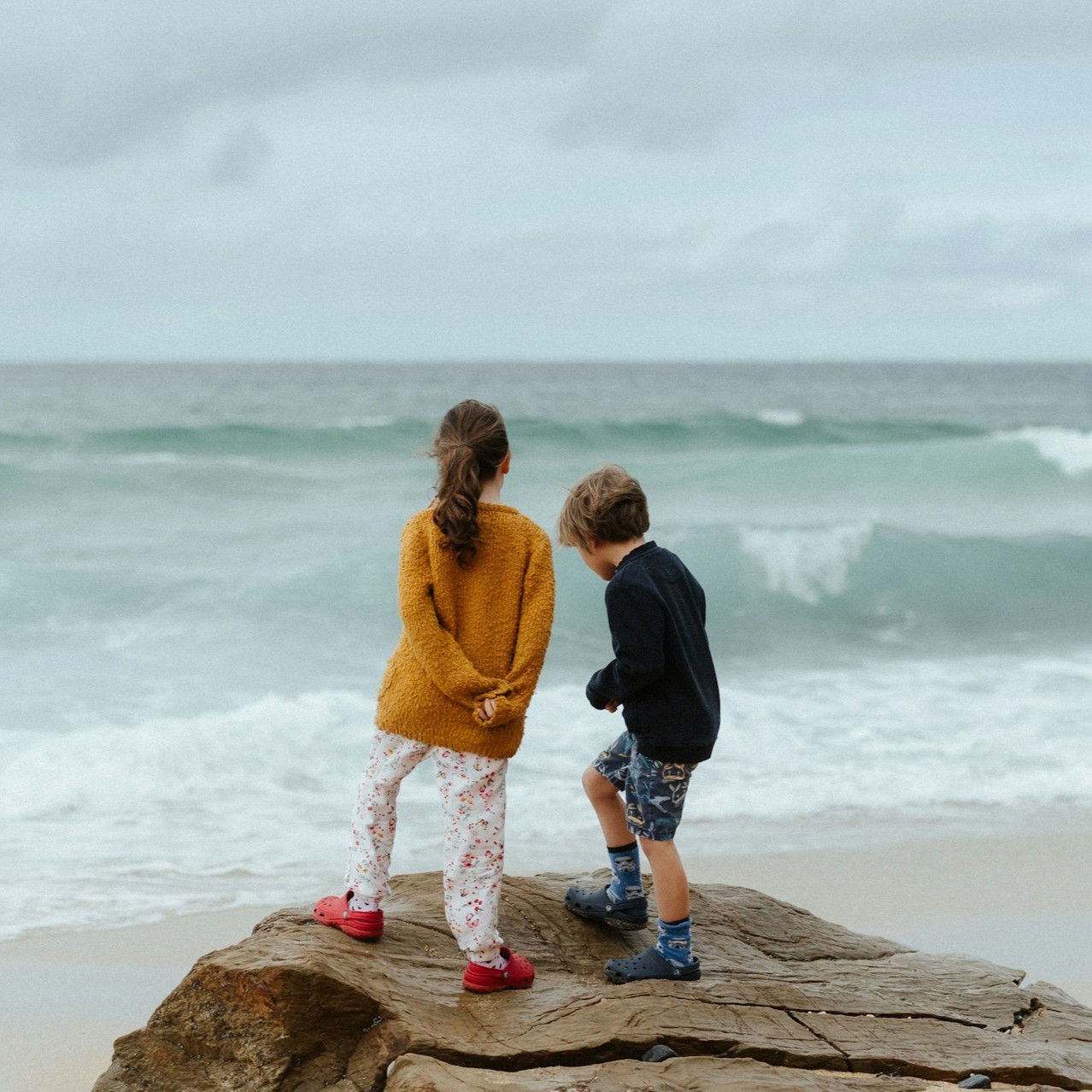 kids-watching-sea-on-stone